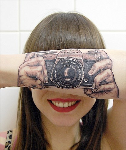 Cute girl smile camera tattoo on arm
