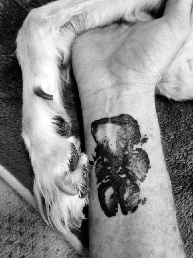 Cute simple pawprints dog tattoo on arm