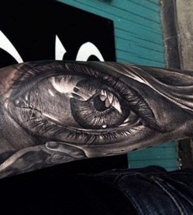 Deep black eye tattoo on arm