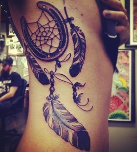 Feather and black horse shoe tattoo