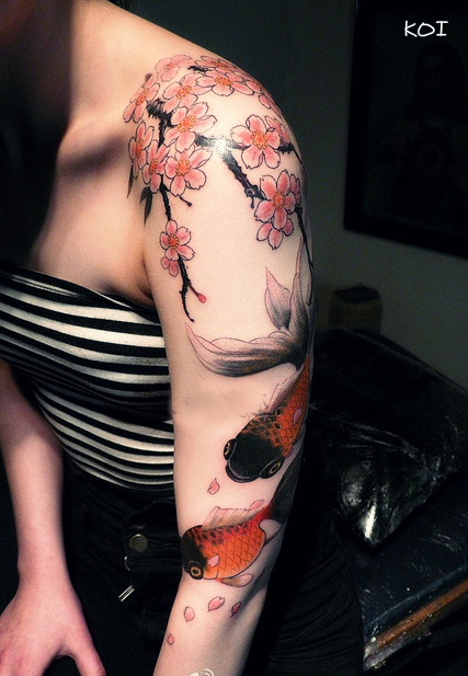 Fish and blossom tree cherry tattoo on arm