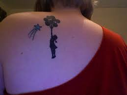 Girl with balloons tattoo on back