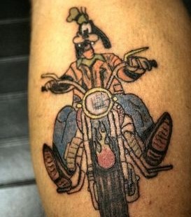 Goofy cartoon bicycle tattoo on leg