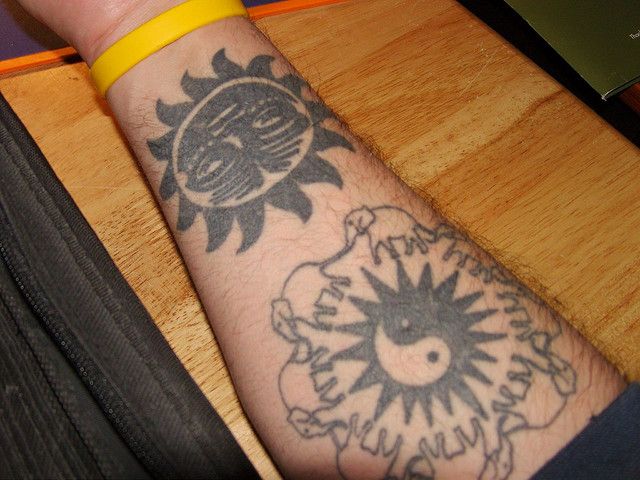 Gorgeous elephants and sun tattoo on arm