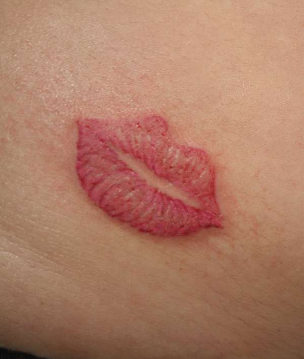 Gorgeous red lips tattoo on arm