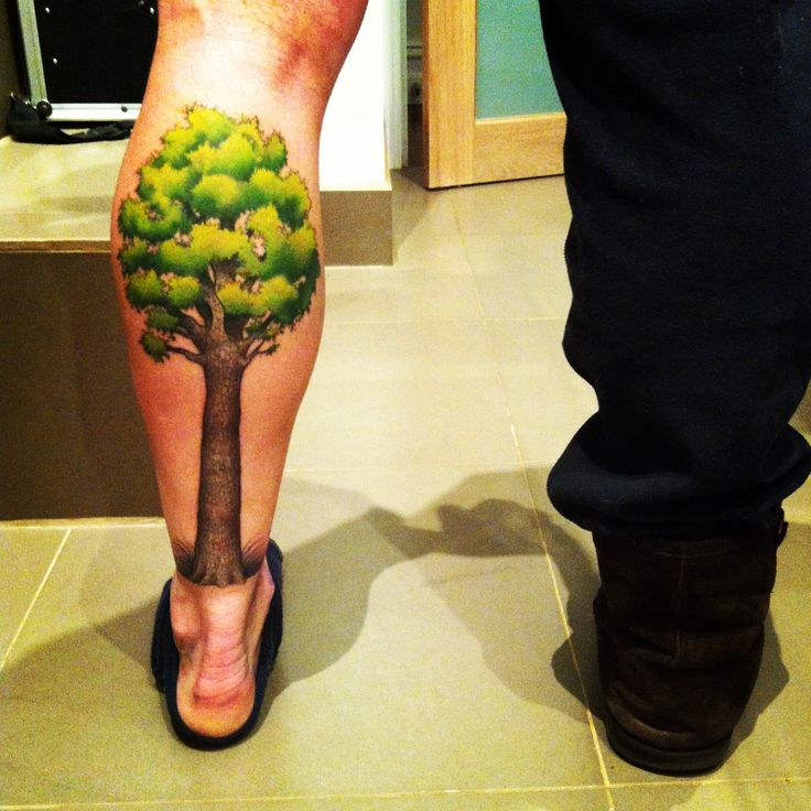 Green and brown tree tattoo on leg
