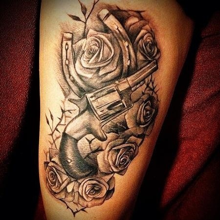 Gun, roses and horse shoe tattoo
