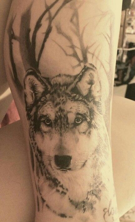 Large tree and wolf tattoo on leg