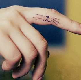 Little black cat tattoo on finger