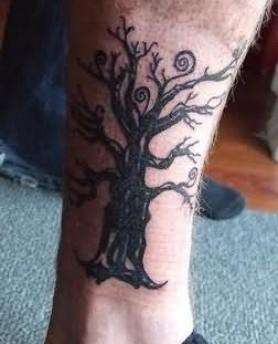 Lovely black tree tattoo on leg