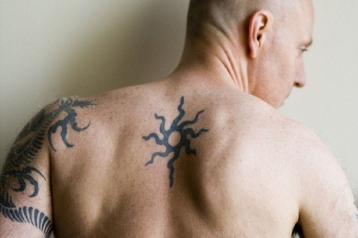 Men’s black back sun tattoo