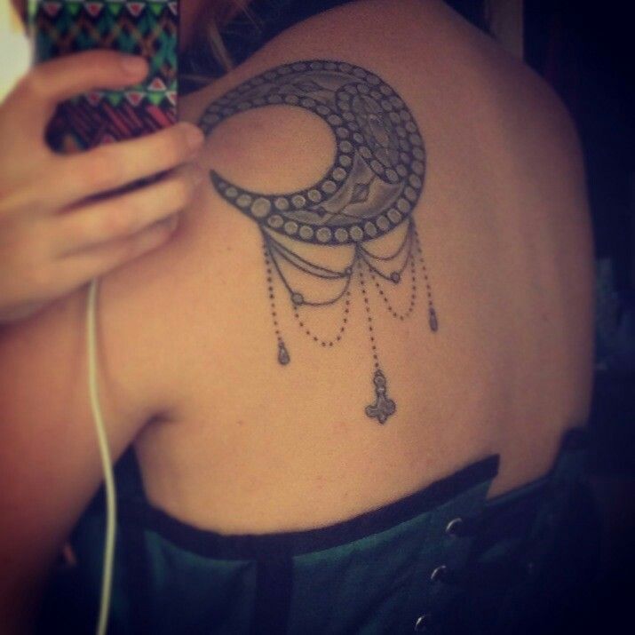 Moon, ornaments and sun tattoo on shoulder