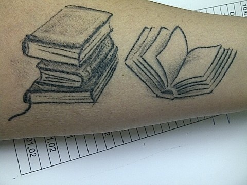 Numbers and black book tattoo on arm