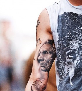 Old men's face tattoo on arm