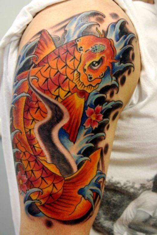 Orange simple fish tattoo on arm