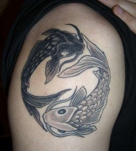 Owal of black fish tattoo on arm