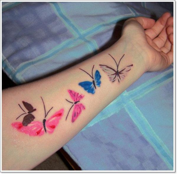 Pink and blue butterfly tattoo on arm