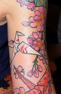 Pink flowers and origami tattoo on arm