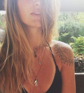 Pretty blonde girl sun tattoo on shoulder