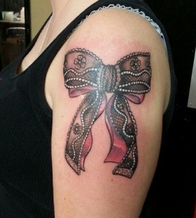 Pretty bow and lace tattoo on arm