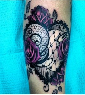 Purple rose and lace tattoo on arm