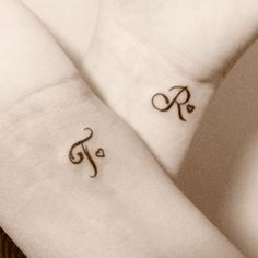 R and T letters tattoos on hands
