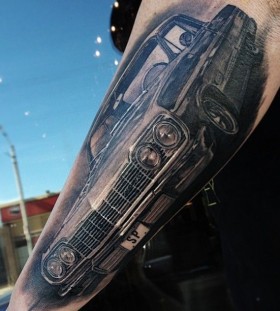 Realistic black car tattoo on arm