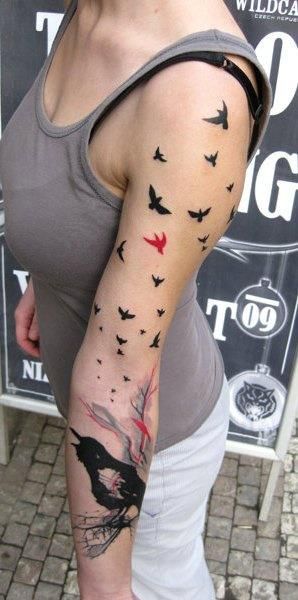 Red and black bird tattoo on arm