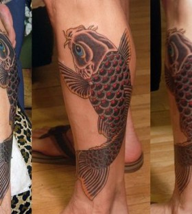 Red and black fish tattoo on leg