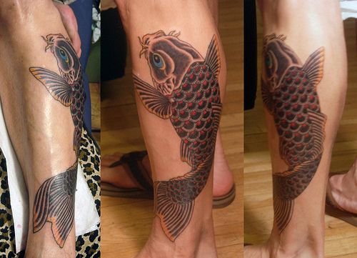 Red and black fish tattoo on leg