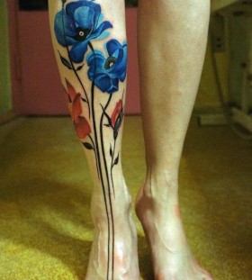 Red and blue poppy tattoo on leg