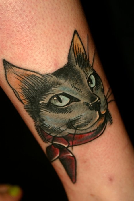 Red bow and cat tattoo on leg