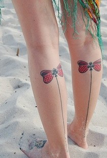 Red bow and line tattoo on leg