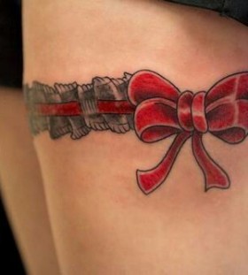 Red bow and pretty lace tattoo on leg