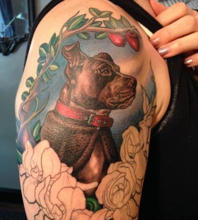 Red cherries, green leafs and dog tattoo on arm