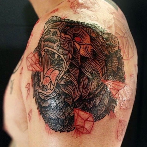 Red crystals and bear tattoo on shoulder