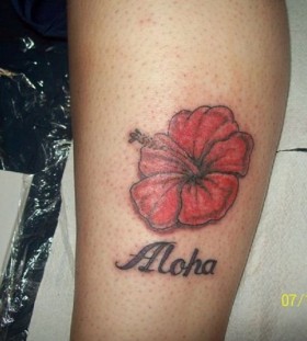 Red flower and quote tattoo on leg