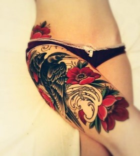 Red flowers and bird tattoo on leg