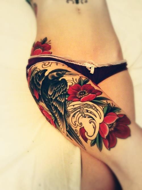 Red flowers and bird tattoo on leg