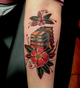 Red flowers and book tattoo on arm