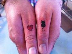 Red heart and cat tattoo on finger