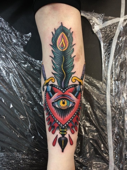 Red heart and eye tattoo on arm