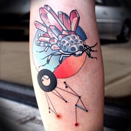 Red insect crystal tattoo on leg
