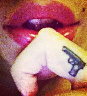 Red lips and finger gun tattoo