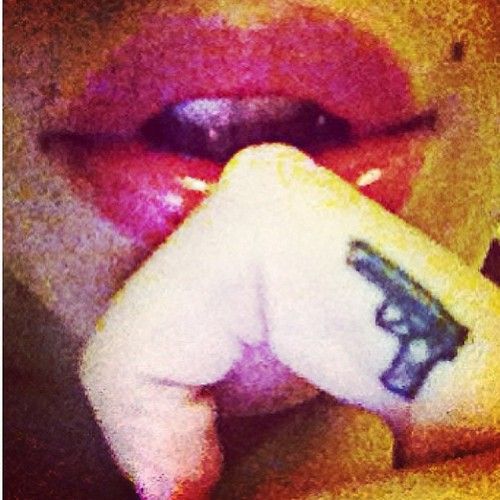 Red lips and finger gun tattoo