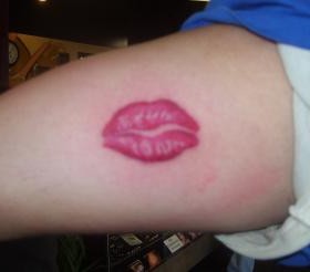 Red lonely lips tattoo on arm