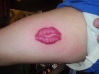 Red lonely lips tattoo on arm