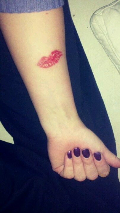 Red lovely lips tattoo on arm