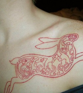 Red ornamental rabbit tattoo on body