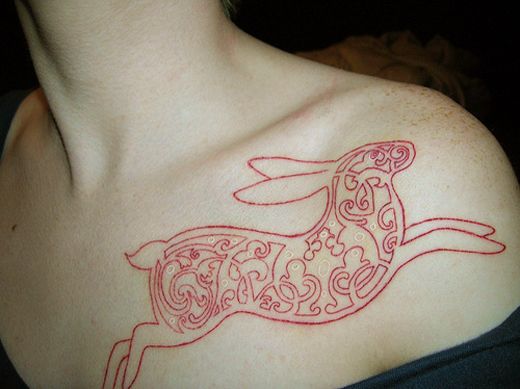 Red ornamental rabbit tattoo on body